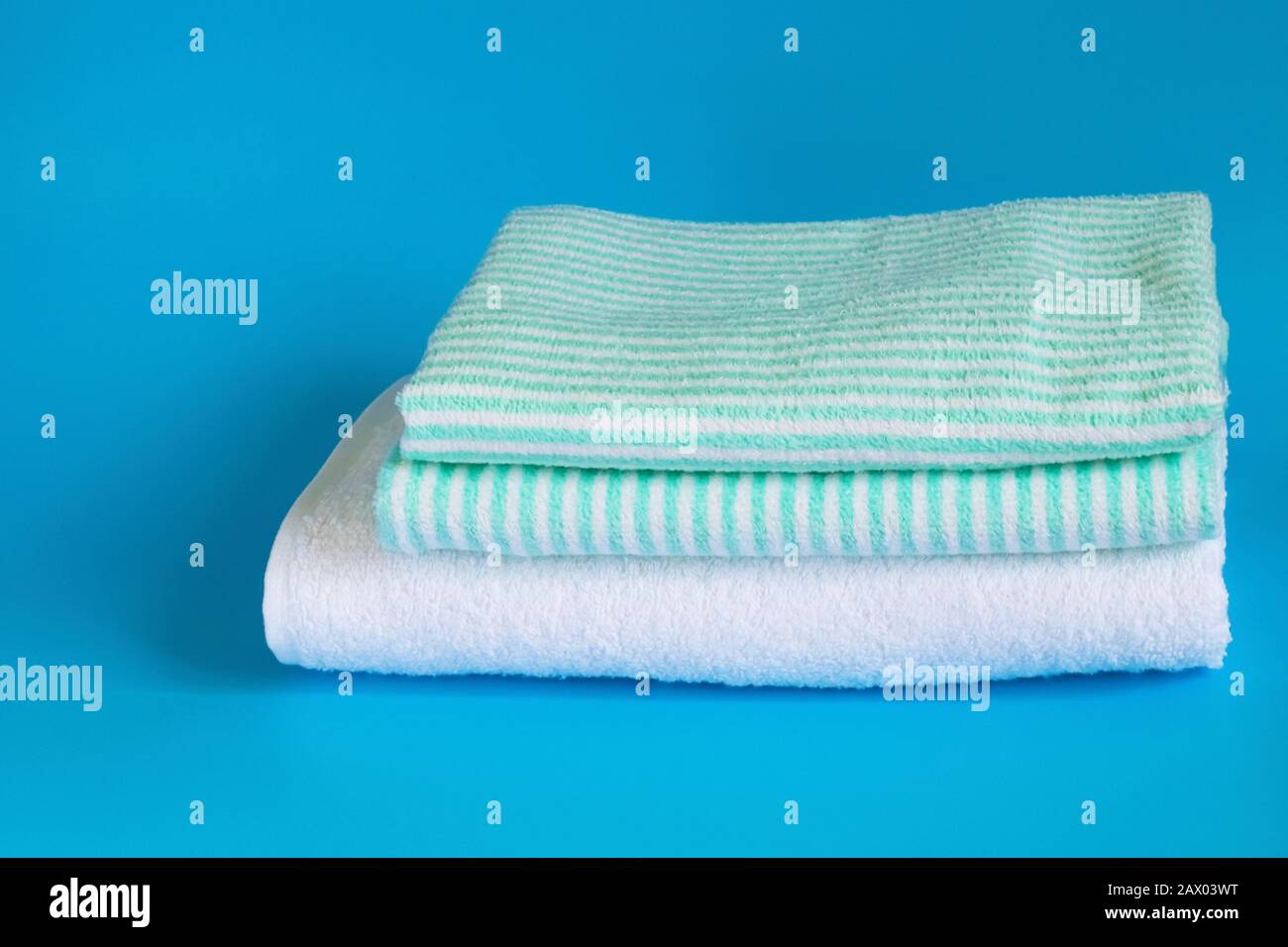 Soft terry cotton towel on a blue background. Bath towel. Personal hygiene items. Stock Photo
