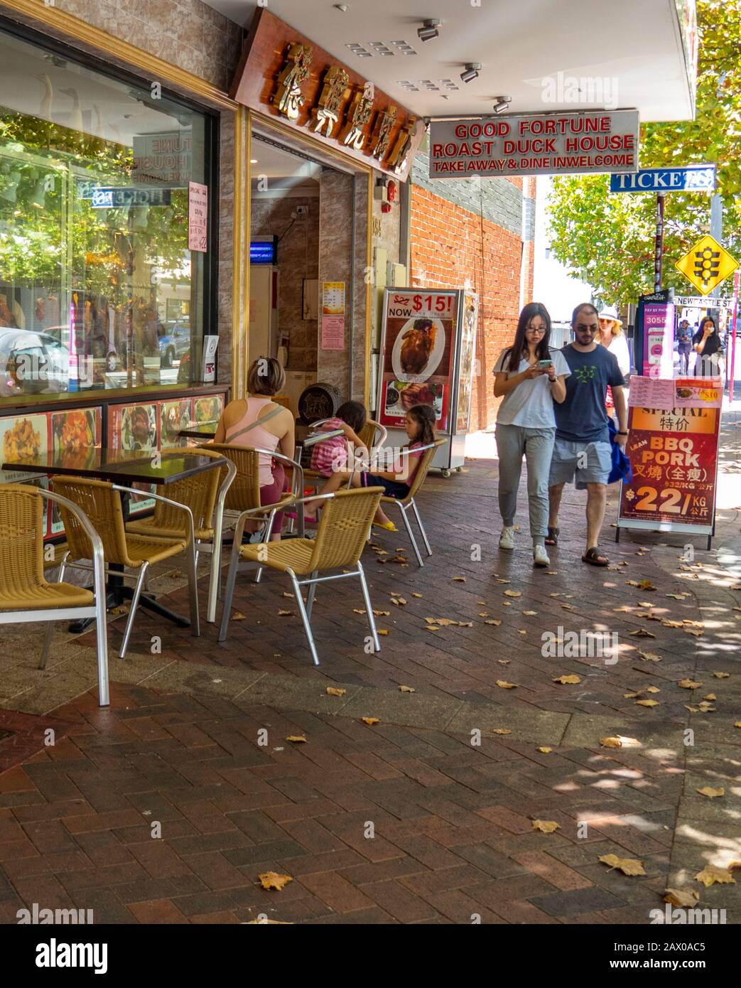 Pedestrians walking past alfresco diners by popular Chinese Restaurant Good Fortune Roast Duck