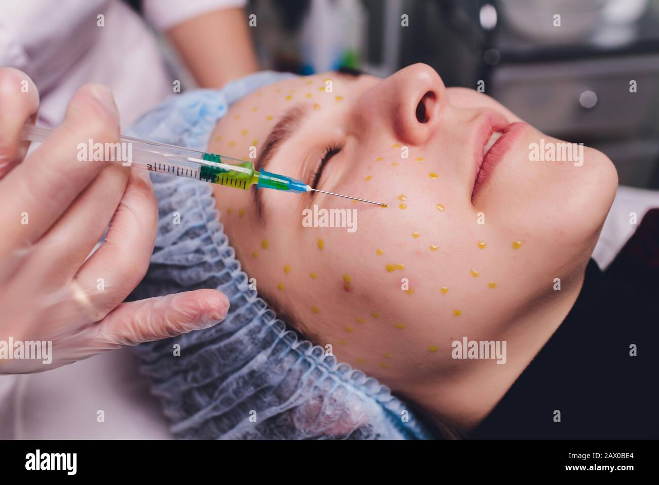 The doctor cosmetologist makes the biorepil facial injections procedure ...