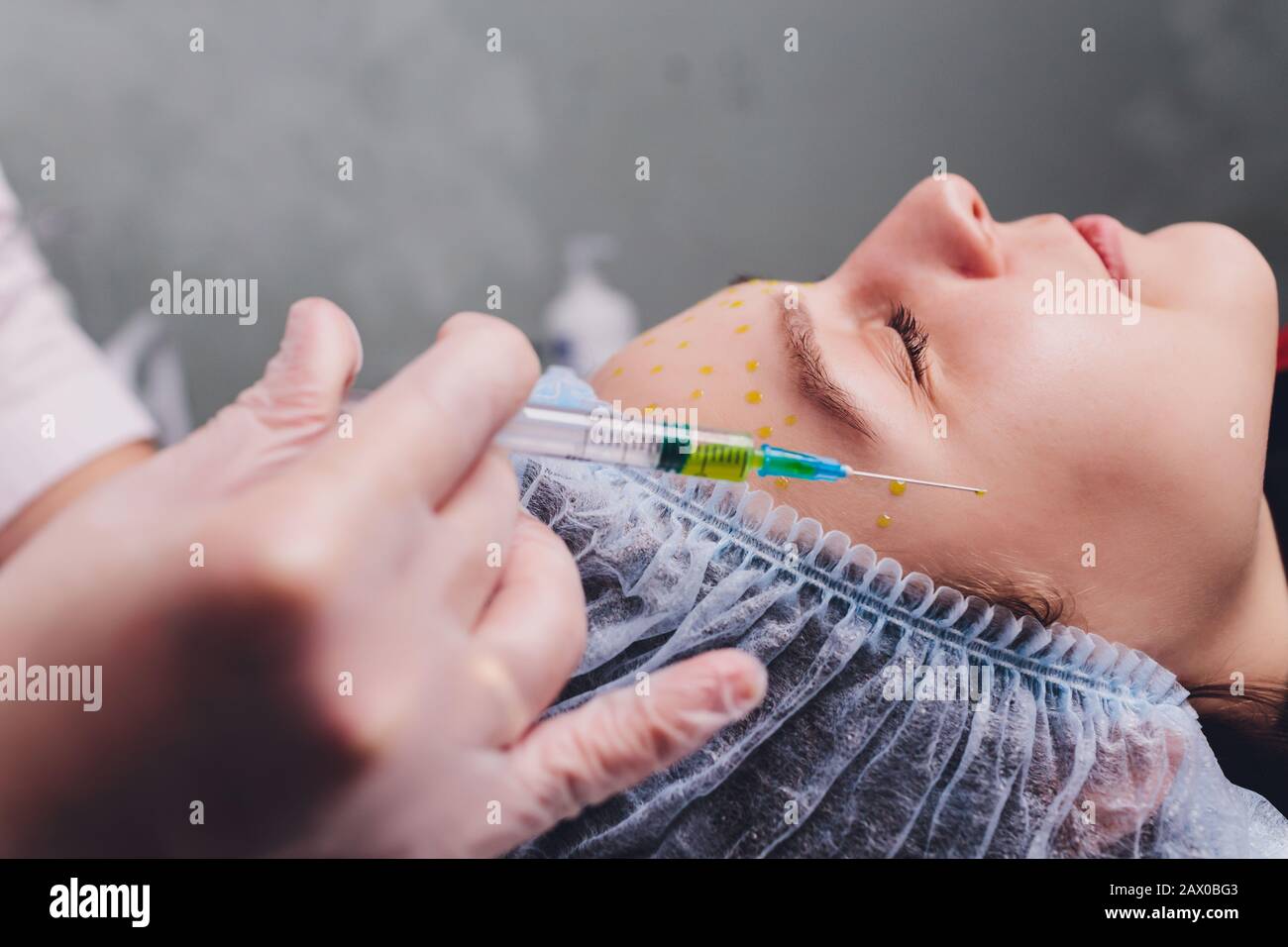 The doctor cosmetologist makes the biorepil facial injections procedure ...