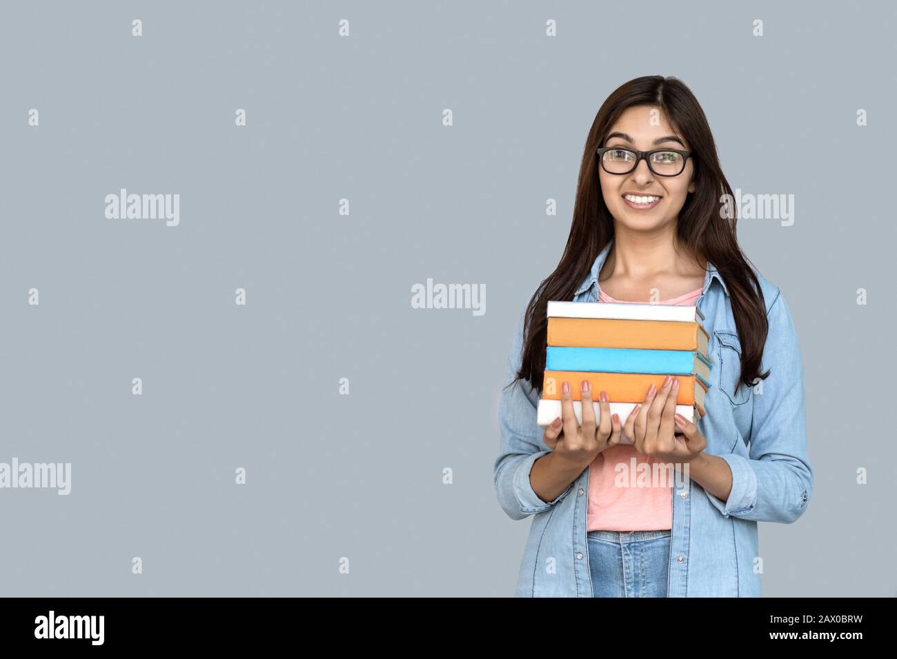 Young adult indian student girl holding books in hands Stock Photo