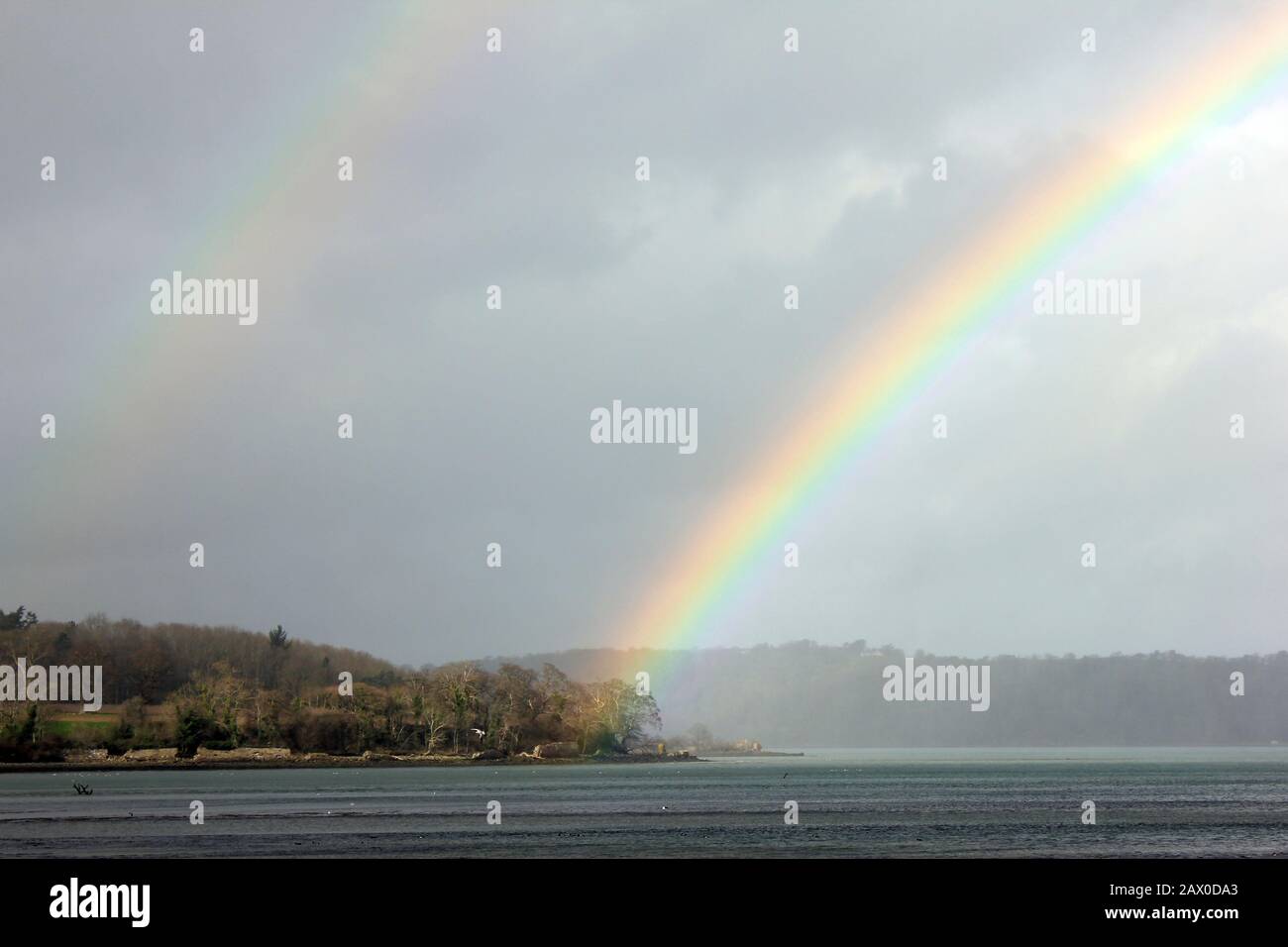 Double Rainbow over the Menai Strait looking towards Anglesey. As viewed from Spinnies Aberogwen Nature Reserve, North Wales Stock Photo