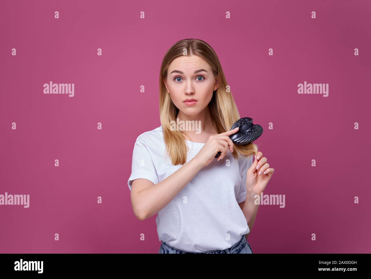 girl with a comb and problem hair, blonde hair, young woman Stock Photo