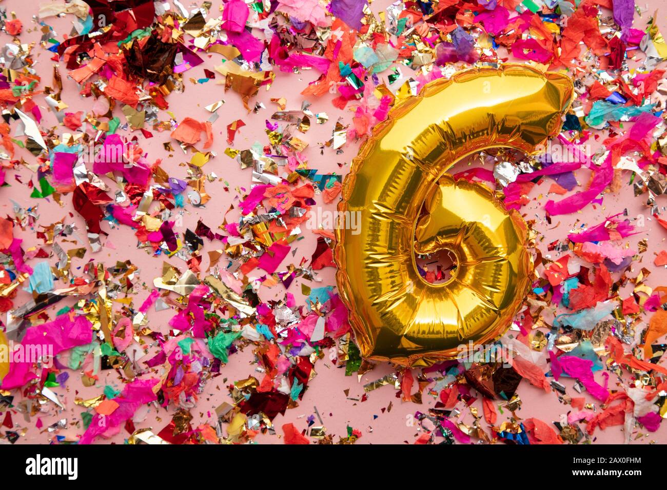 Number 6 gold birthday celebration balloon on a confetti glitter