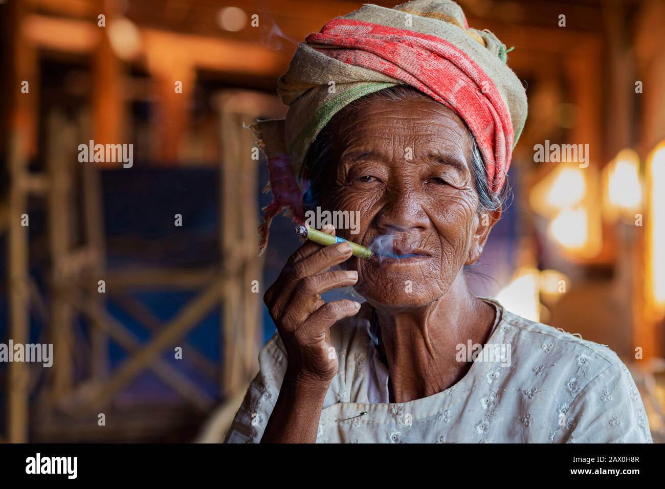 Old lady of Pa'O ethnic minority smoking a Burmese cigar at Indein village near Inle Lake, Shan State, Myanmar. Stock Photo
