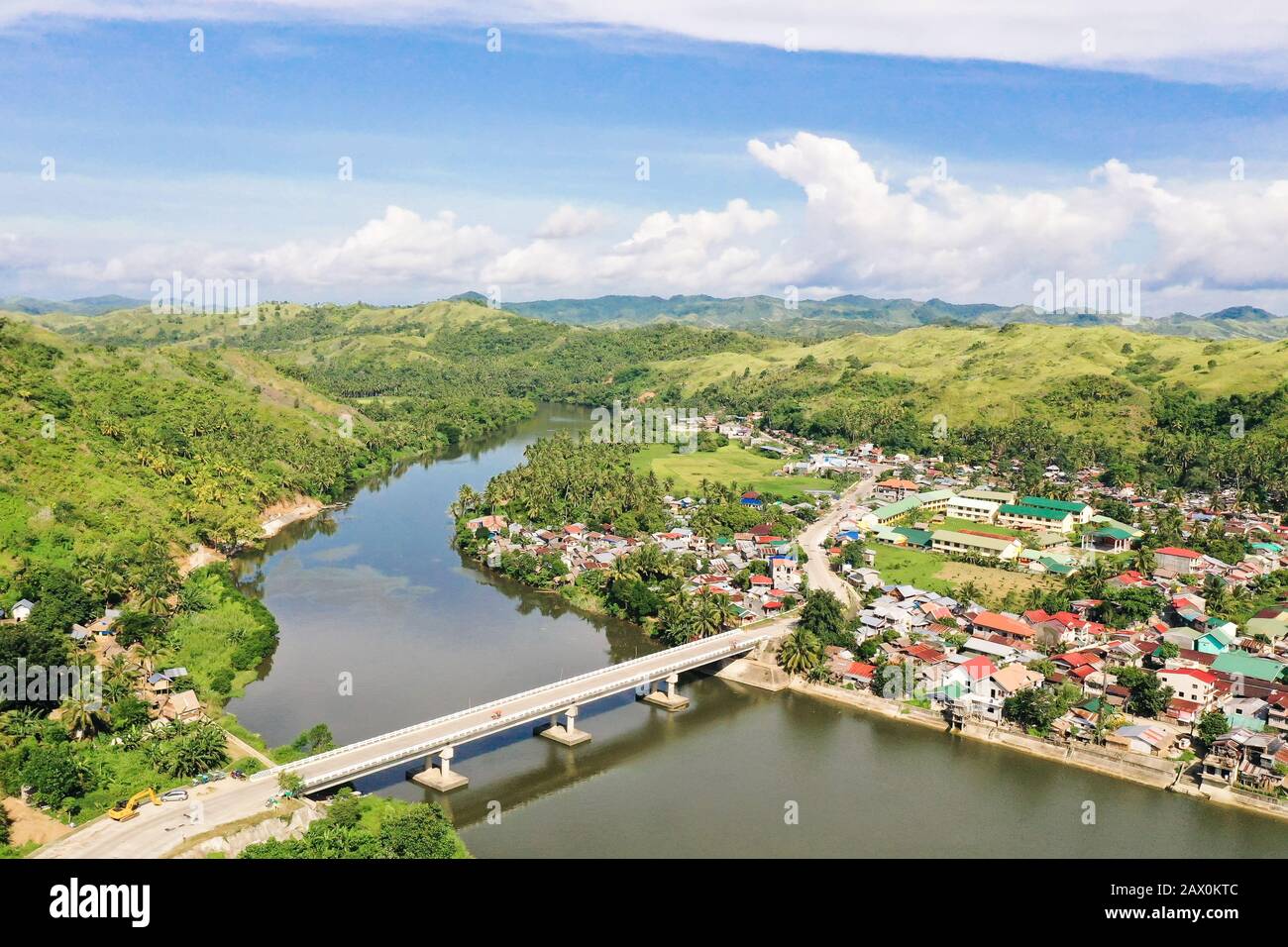 Road bridge on the island of Samar, Philippines.Town on the river bank and road bridge, top view. Bridge over the river, tropical landscape in the afternoon. Summer and travel vacation concept. Stock Photo