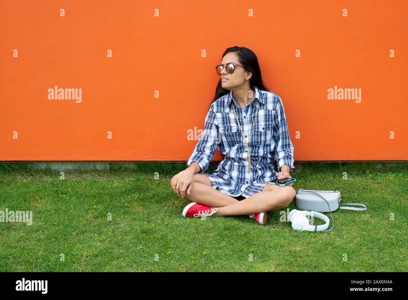 Woman sitting on the grass with a mobile phone in his hands, Panama, Central America Stock Photo