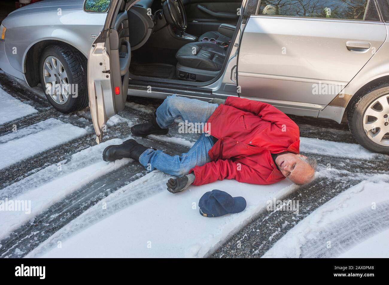 Senior man slipped on ice coming out of his car Stock Photo