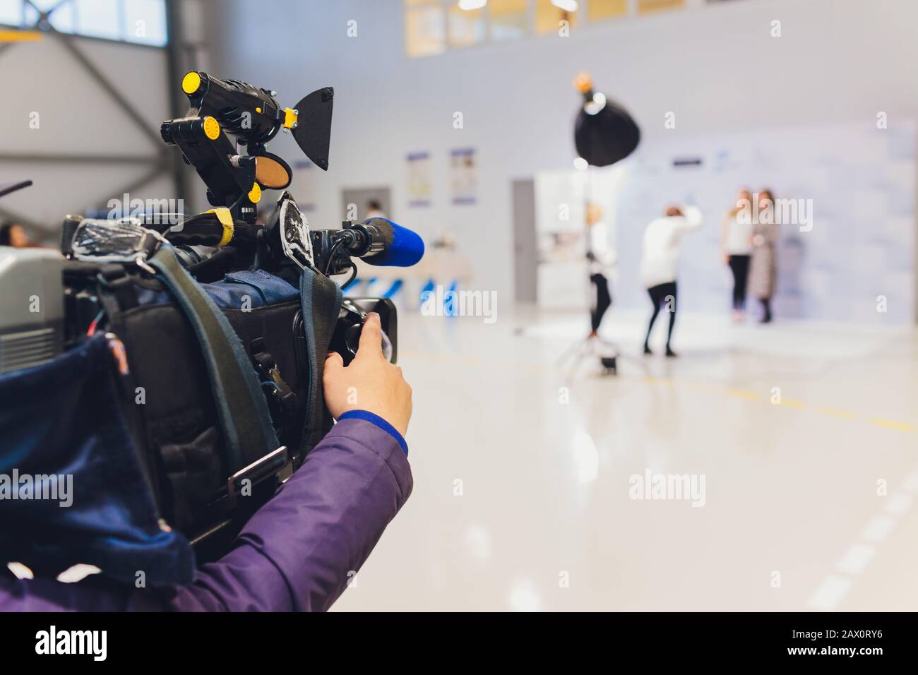 Cameraman using black professional digital video camera. Outdoor setup