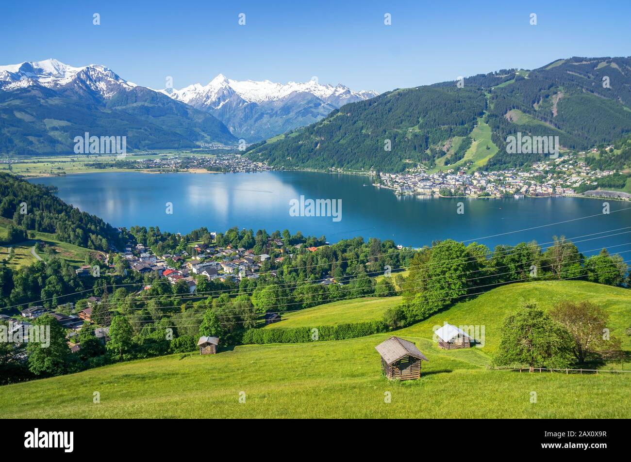 Panoramic view of beautiful scenery in the Alps with mountain lake and meadows with old chalets in spring, Zell am See, Salzburger Land, Austria Stock Photo