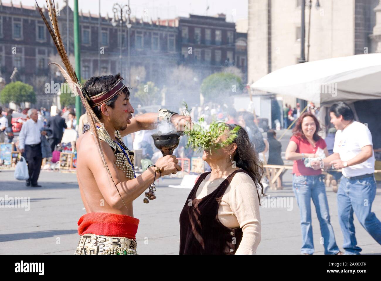 Mexico City - Jan 13, 2007: Aztec Medicine Man using smoke and herbs to cleanse the aura of an elderly indigenous woman on 13 Jan in Zocalo,  Mexico C Stock Photo