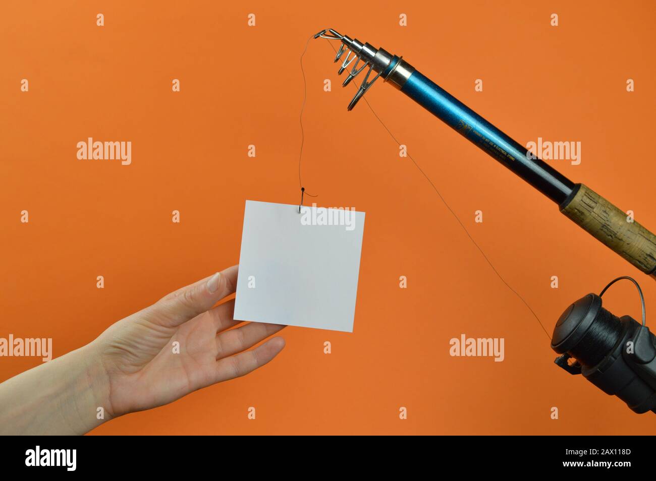 a hand grabbing for a piece of paper hanging from a fishing line a