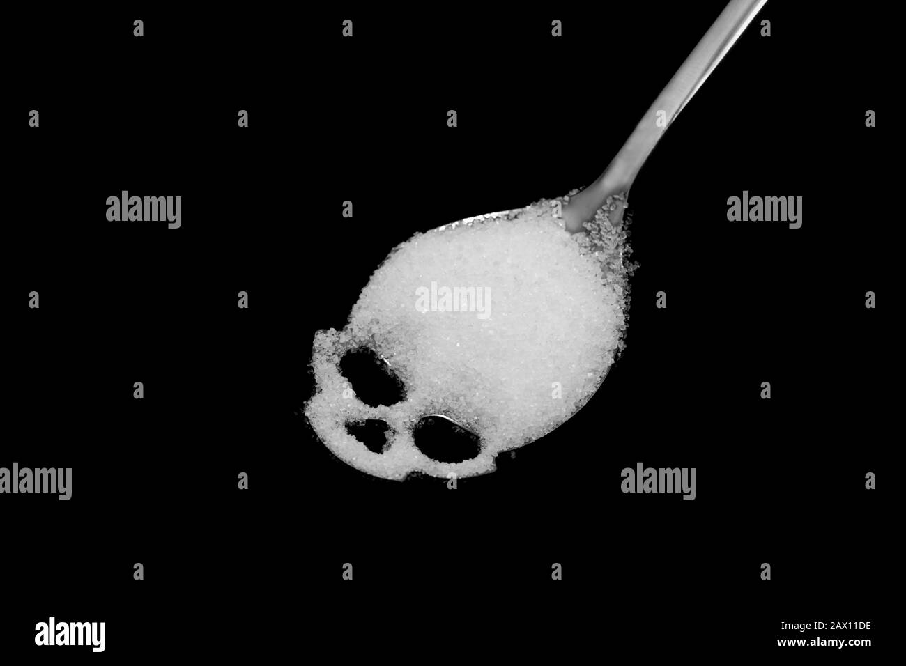 White sugar in skull shape spoon, concept idea is risk of Diabetes mellitus Stock Photo