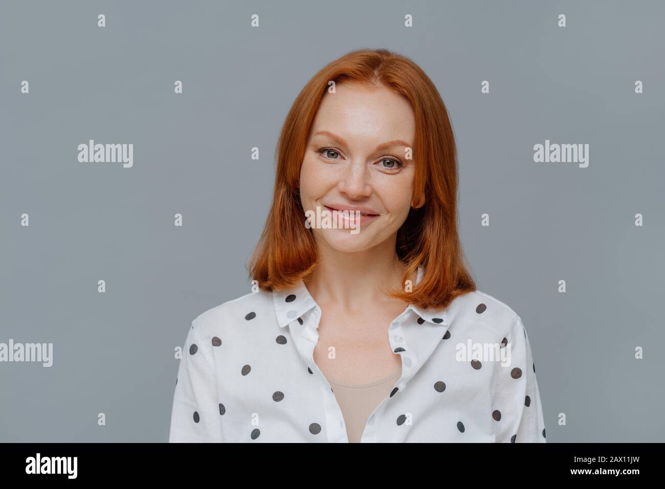 Portrait Of Attractive Ginger European Woman Smiles Gently At Camera Wears Makeup Dressed In 