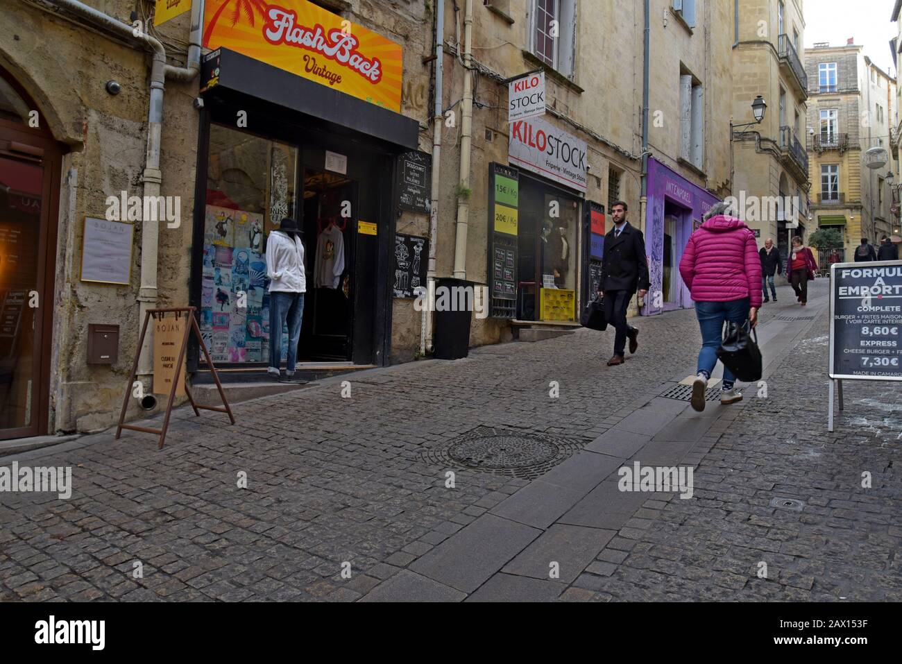 People walking past vintage clothing shops in Rue de l'Université, Montpellier, France Stock Photo