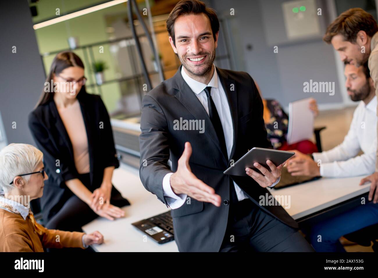 Young businessman using digital tablet in office in front of his team Stock Photo