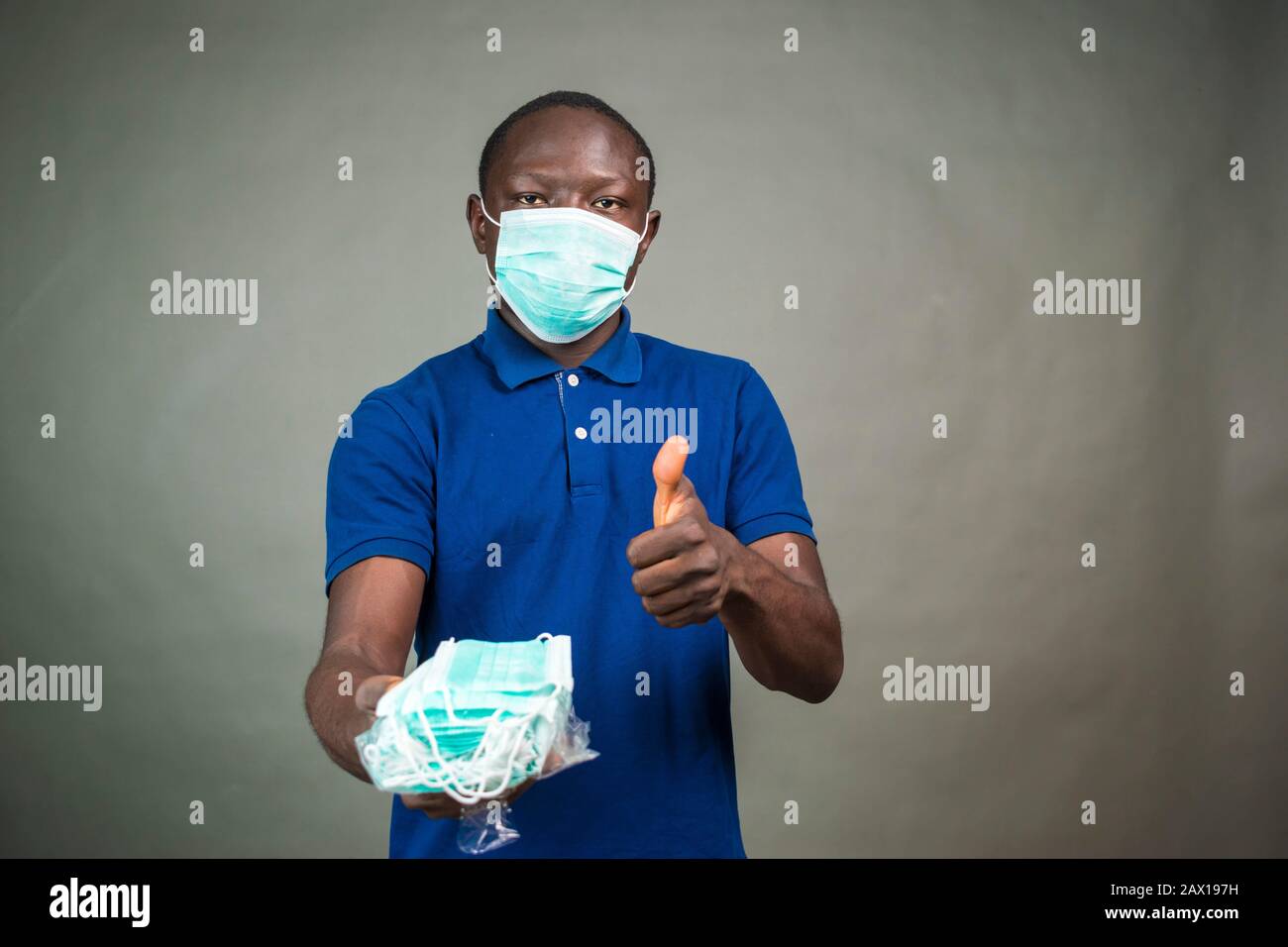 black man handing out face masks, doing thumbs up gesture Stock Photo ...
