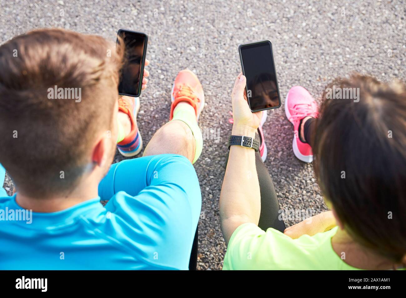 couple of runners sharing their running data with their mobile phones