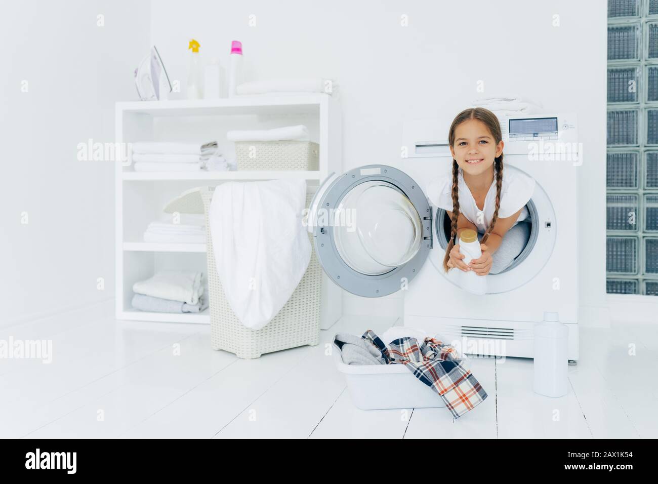 Small girl with appealing appearance, has fun and poses inside of