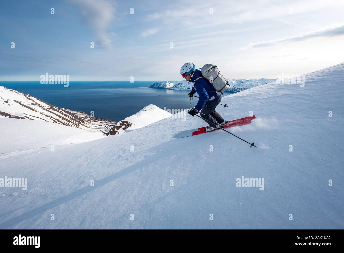 A man skiing downhill with ocean in the background in Iceland Stock Photo