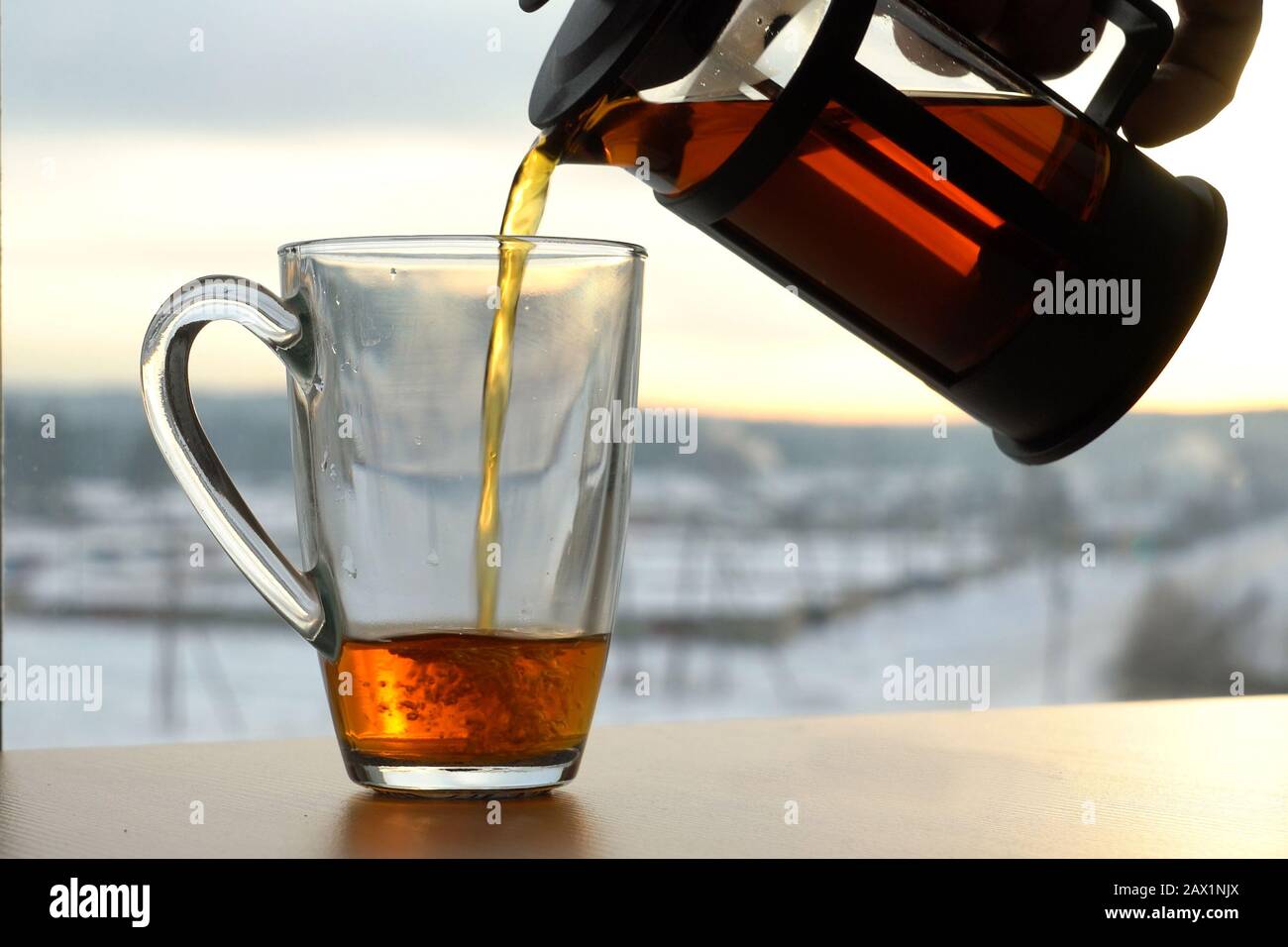 Hot tea ,cup, tea pot at cold morning with sunrise in the foggy mountains  Stock Photo