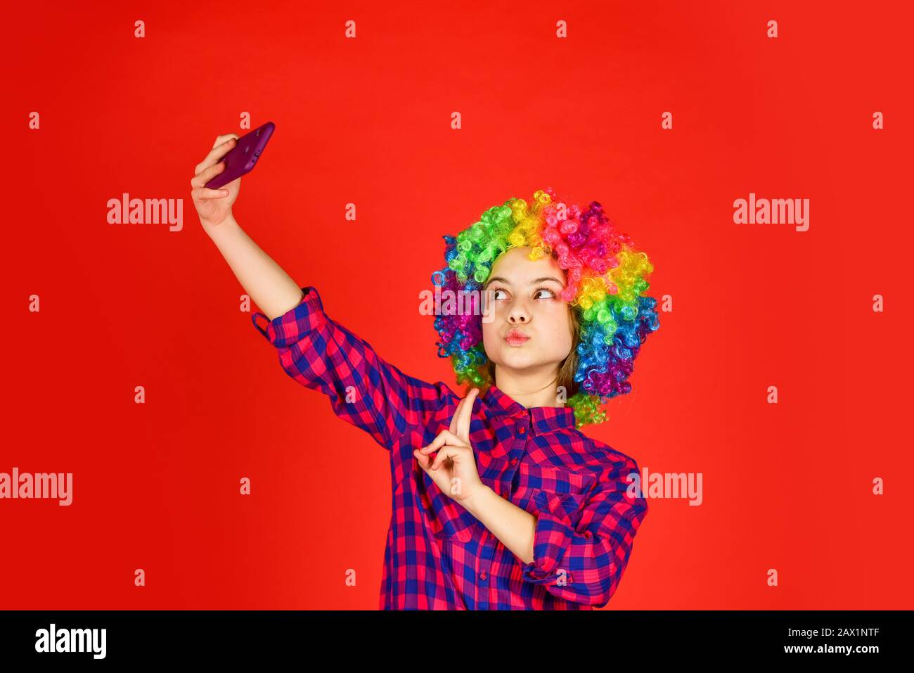 kid looking funny in rainbow wig hair. hair dyeing at hairdresser. child  having fun. happy birthday party. small girl colorful wig make selfie on  phon Stock Photo - Alamy