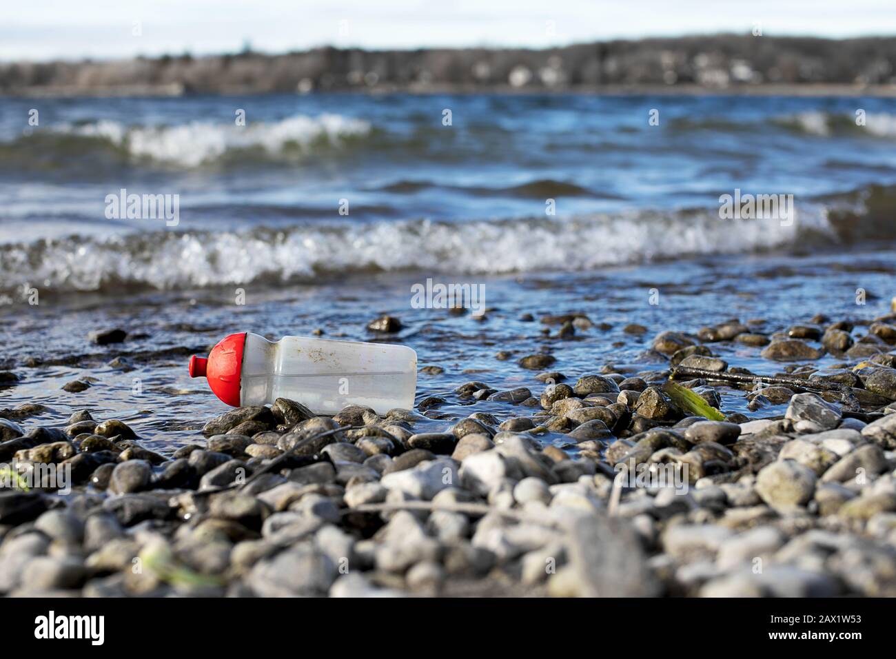 discarded plastic drinking bottle on the beach of the Ammersee Stock Photo