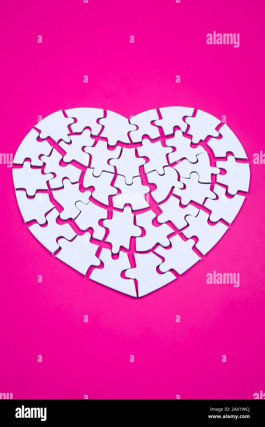 Heart rendered into white puzzle pieces on pink background Stock Photo ...