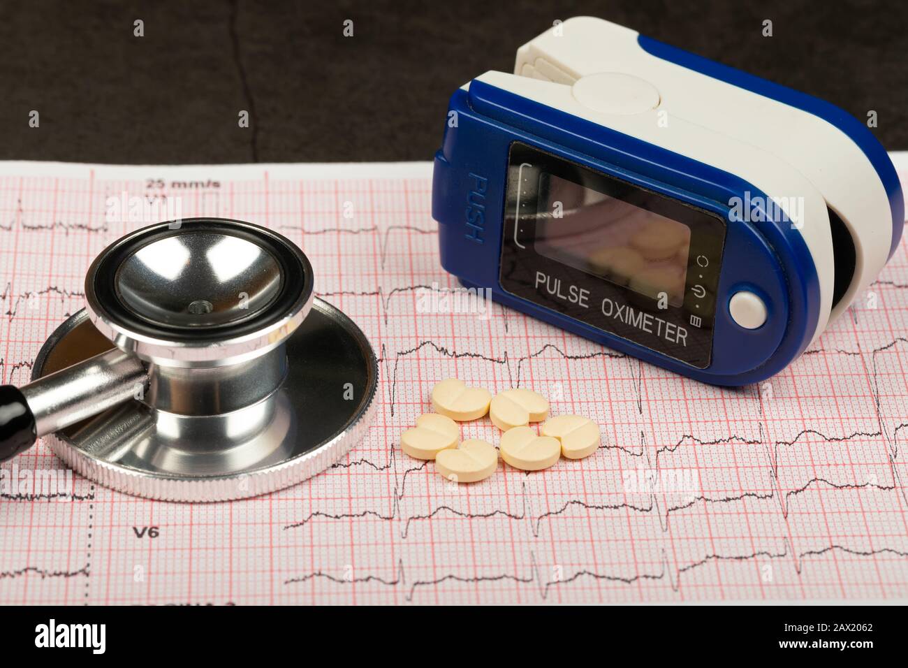 Electrocardiogram graph report with stethoscope and pulse oximeter on it Stock Photo