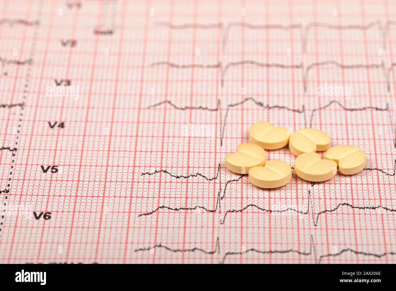 Heart form pills over an electrocardiogram graph Stock Photo