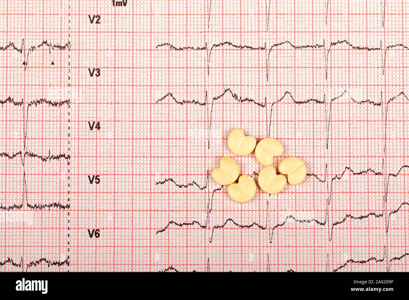 Heart form pills over an electrocardiogram graph Stock Photo