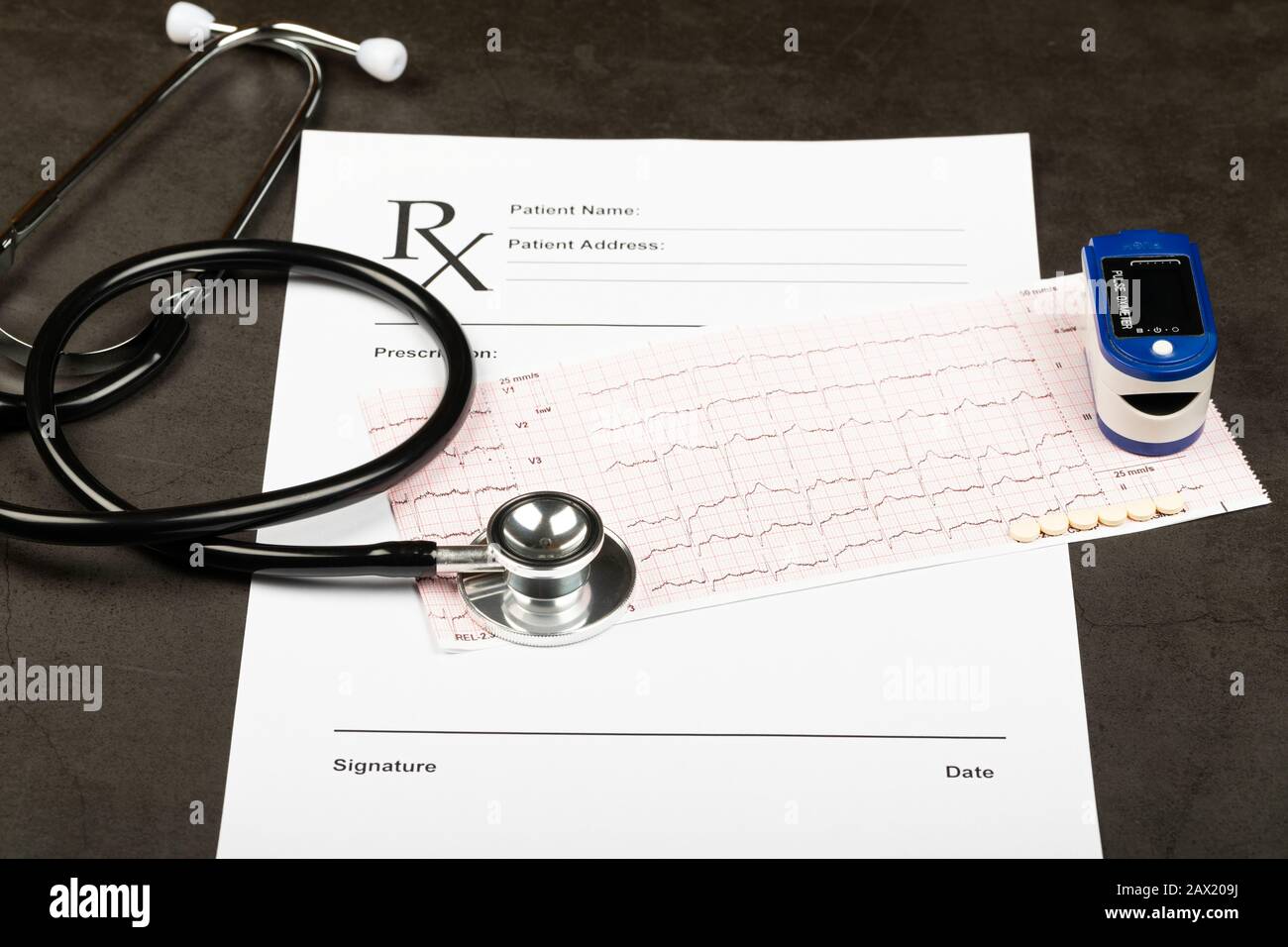 Electrocardiogram graph report with stethoscope and pulse oximeter on it Stock Photo