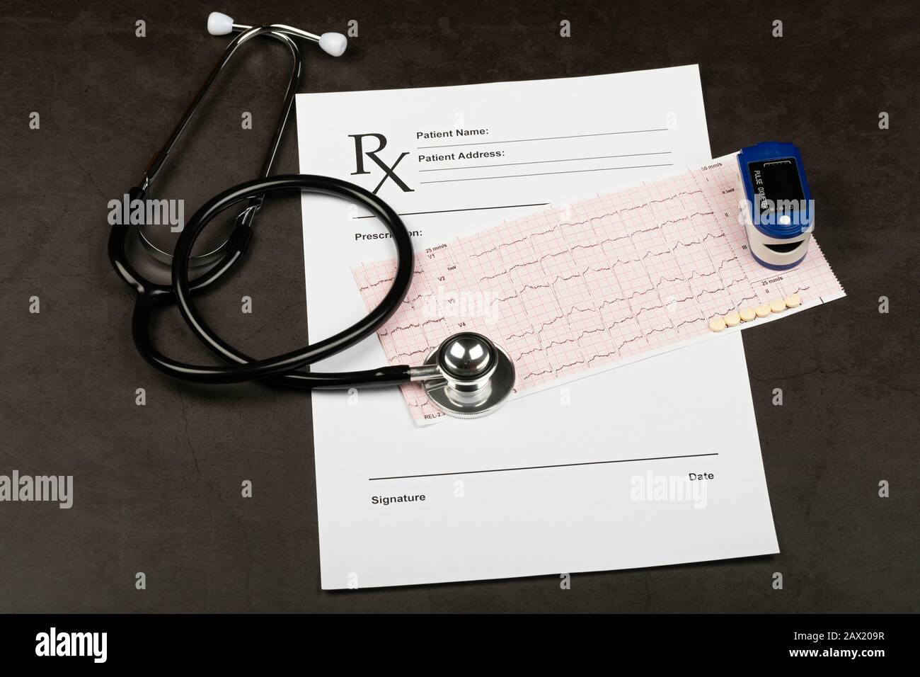Electrocardiogram graph report with stethoscope and pulse oximeter on it Stock Photo