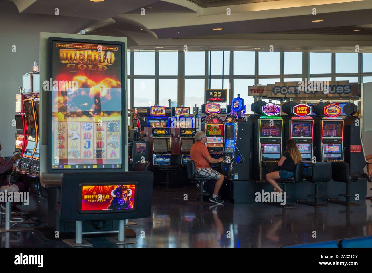 People playing slot machines in airport Stock Photo