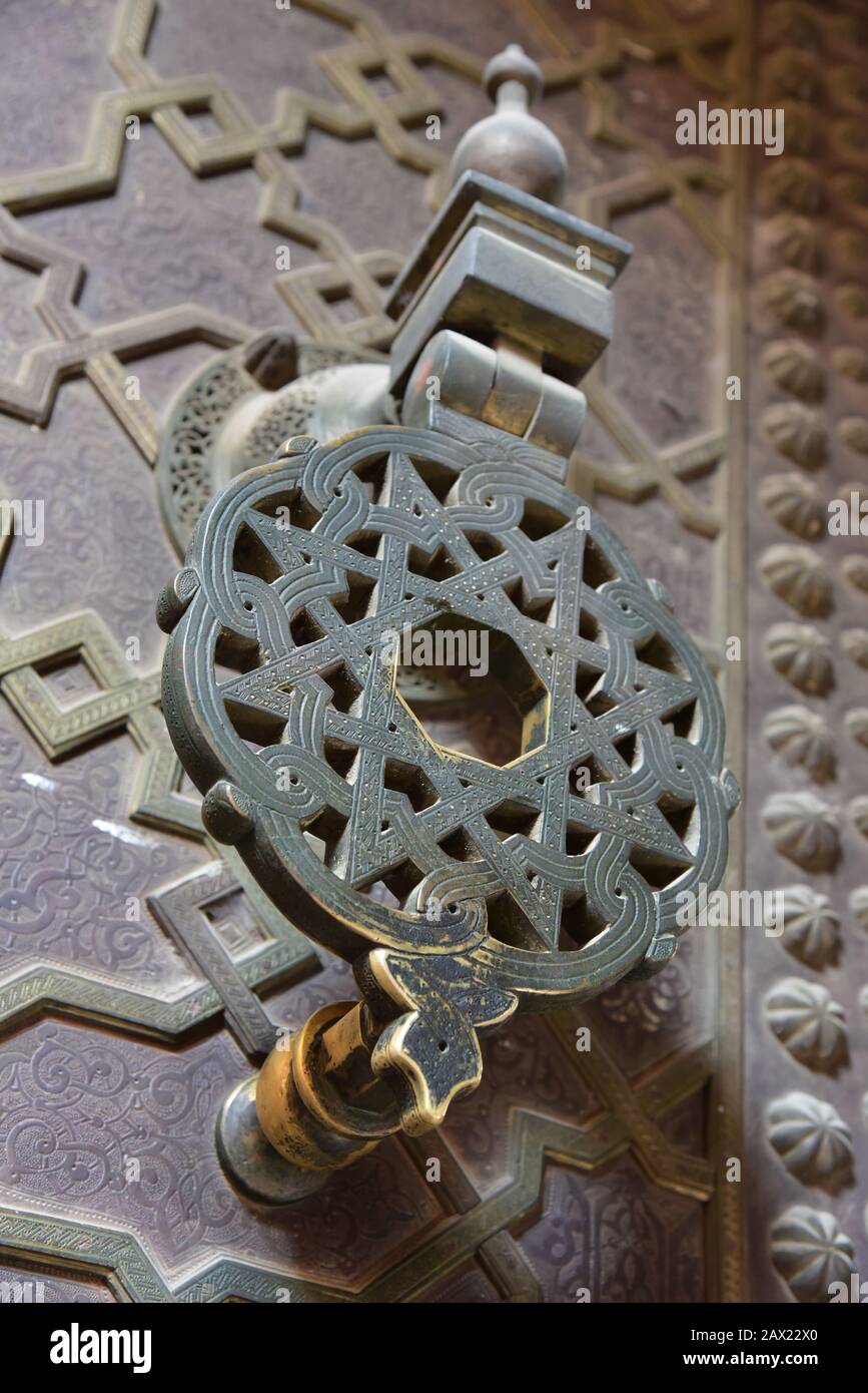 Ornate bronze door knocker, a typical design often seen throughout ancient Morocco, Northern Africa. Stock Photo