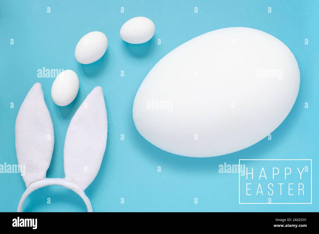 Easter concept. Rabbit ears and white eggs. On a blue background. Stock Photo