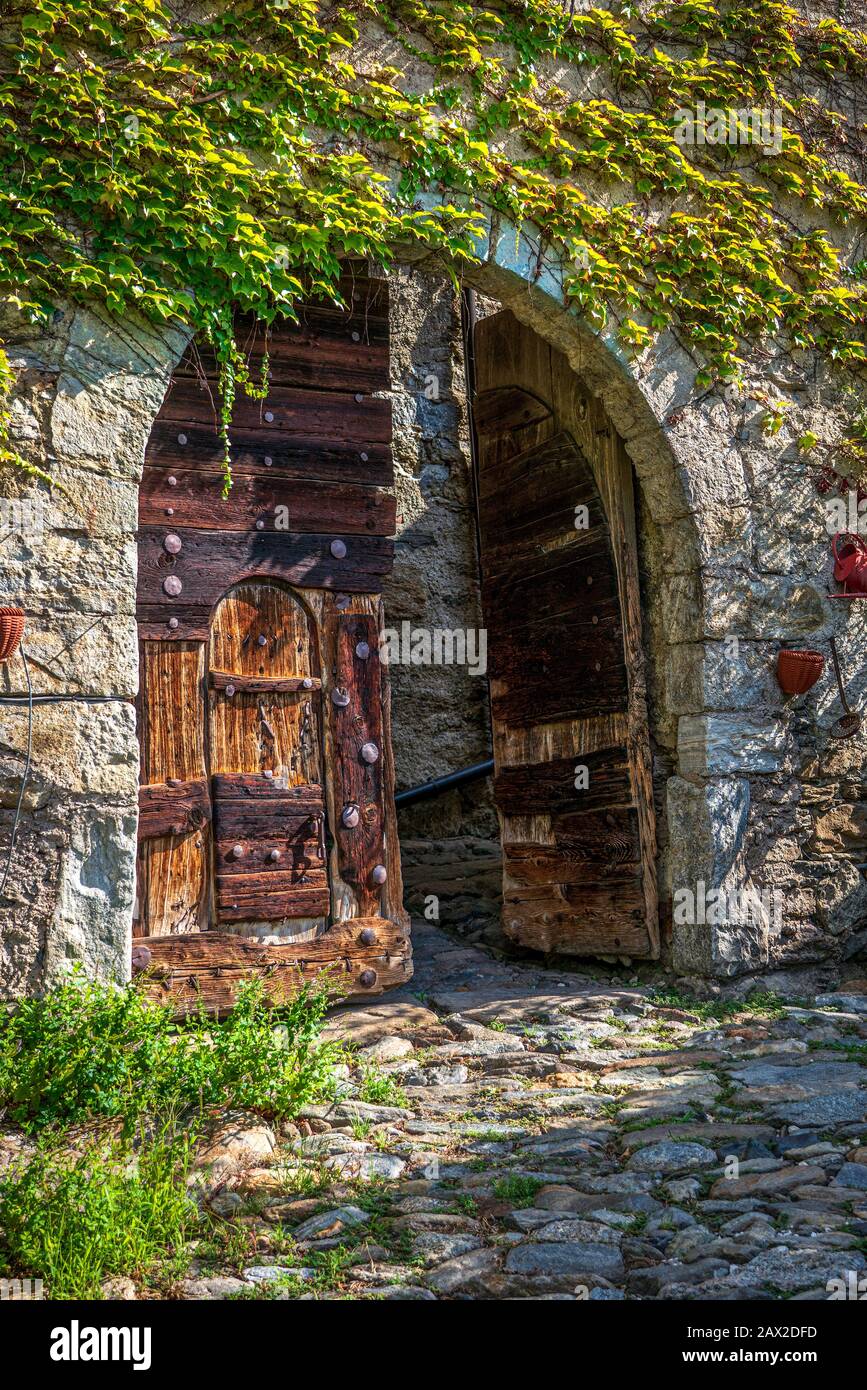 Old wooden doors of an old castle and a stone wall in South Tyrol Stock ...