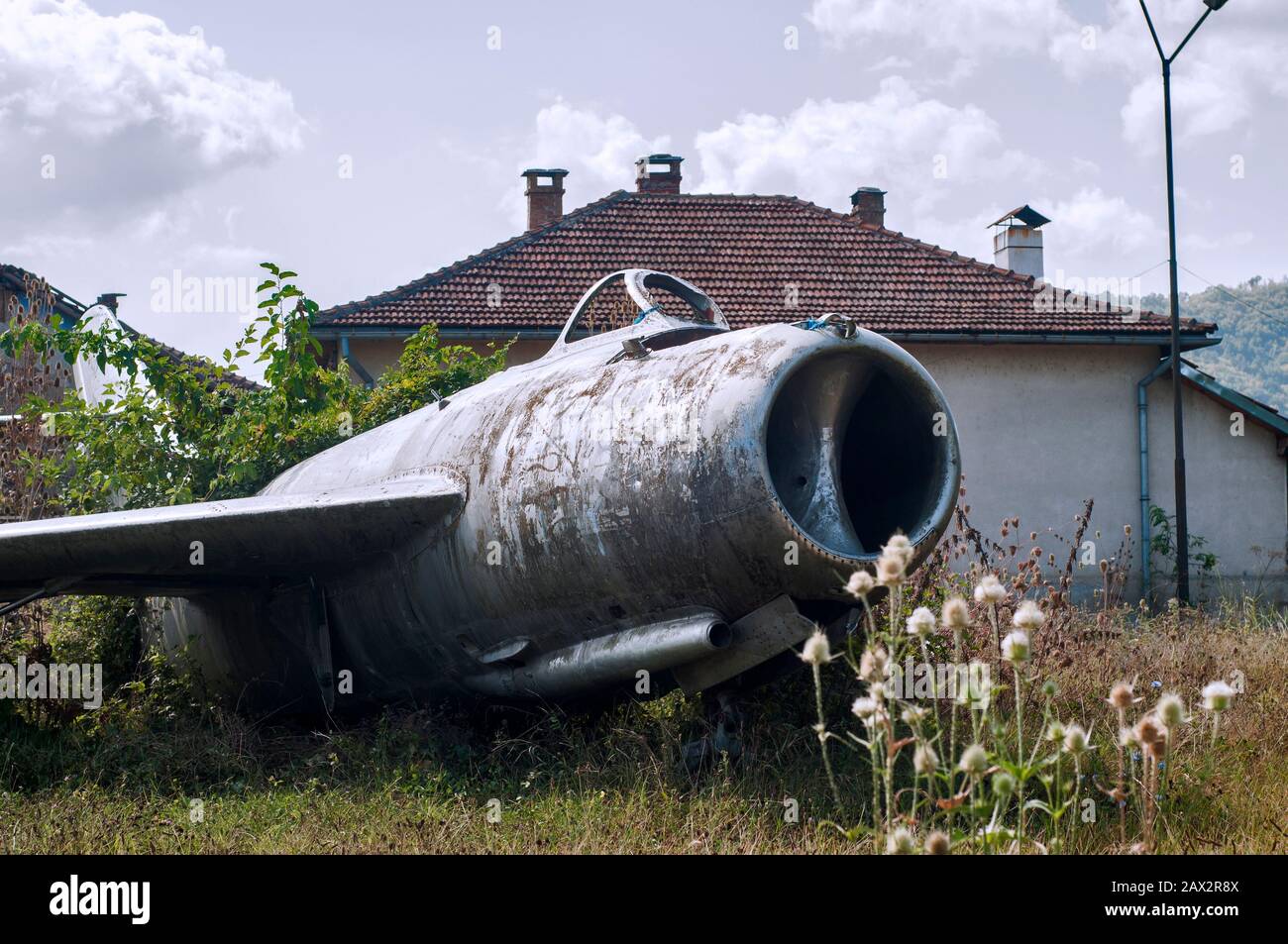 Old neglected Soviet Russian aircraft jet fighter MIG-15 on countryside village meadow Stock Photo