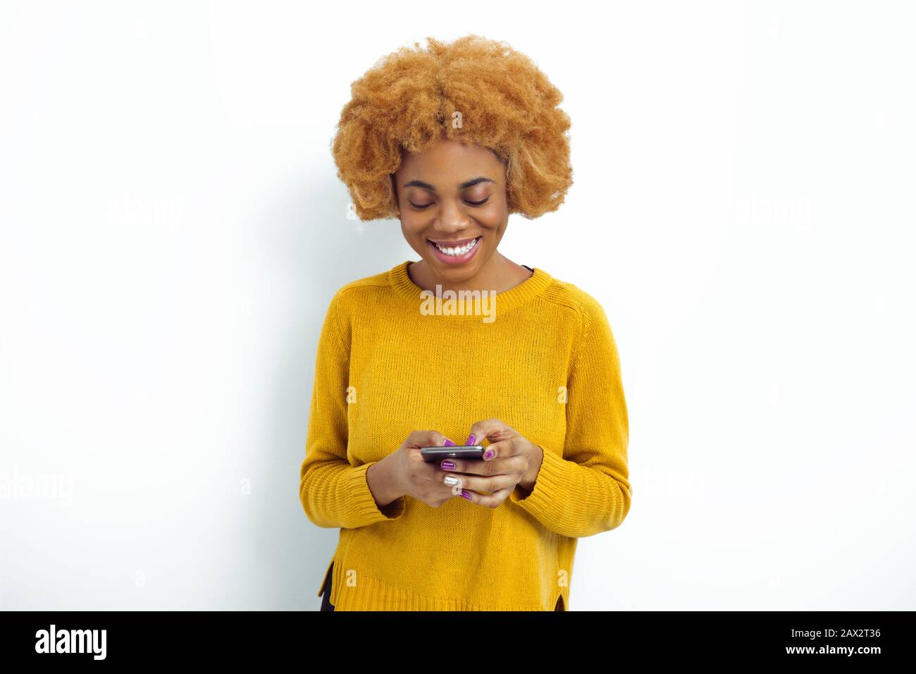 Smiling African American woman holding a mobile phone. Beautiful black ...