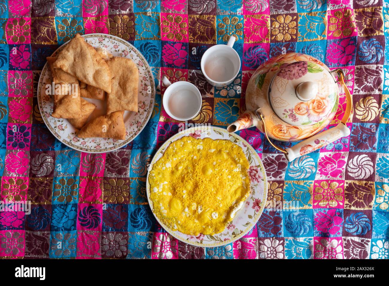 Colorful local breakfast of eggs and arzok bread and chai on a cloth in