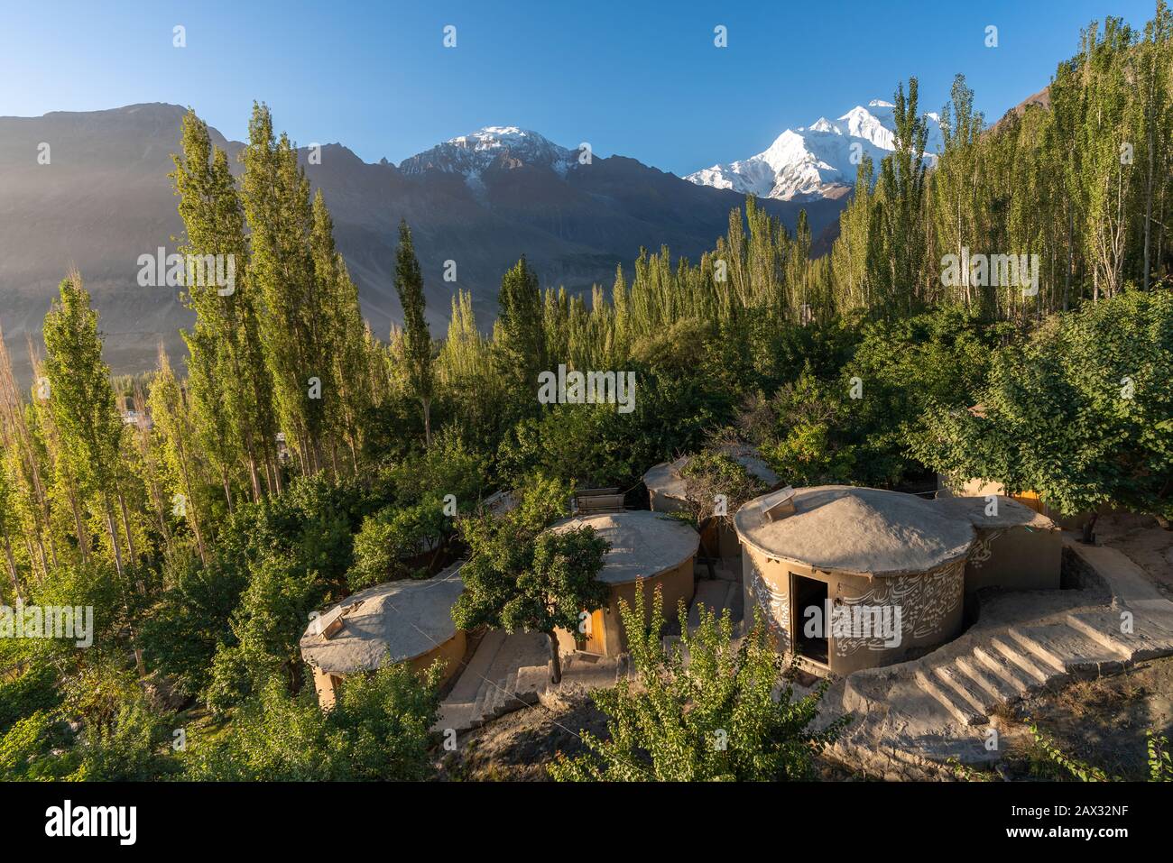 Huts of a boutique local-run hotel on a mountain in front of Rakaposhi in Hunza, Gilgit Baltistan, Pakistan Stock Photo