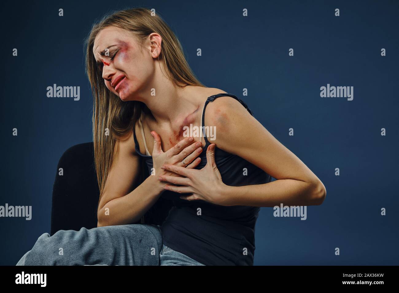 Grieved blonde maiden in black undershirt and jeans. Bleeding face ...