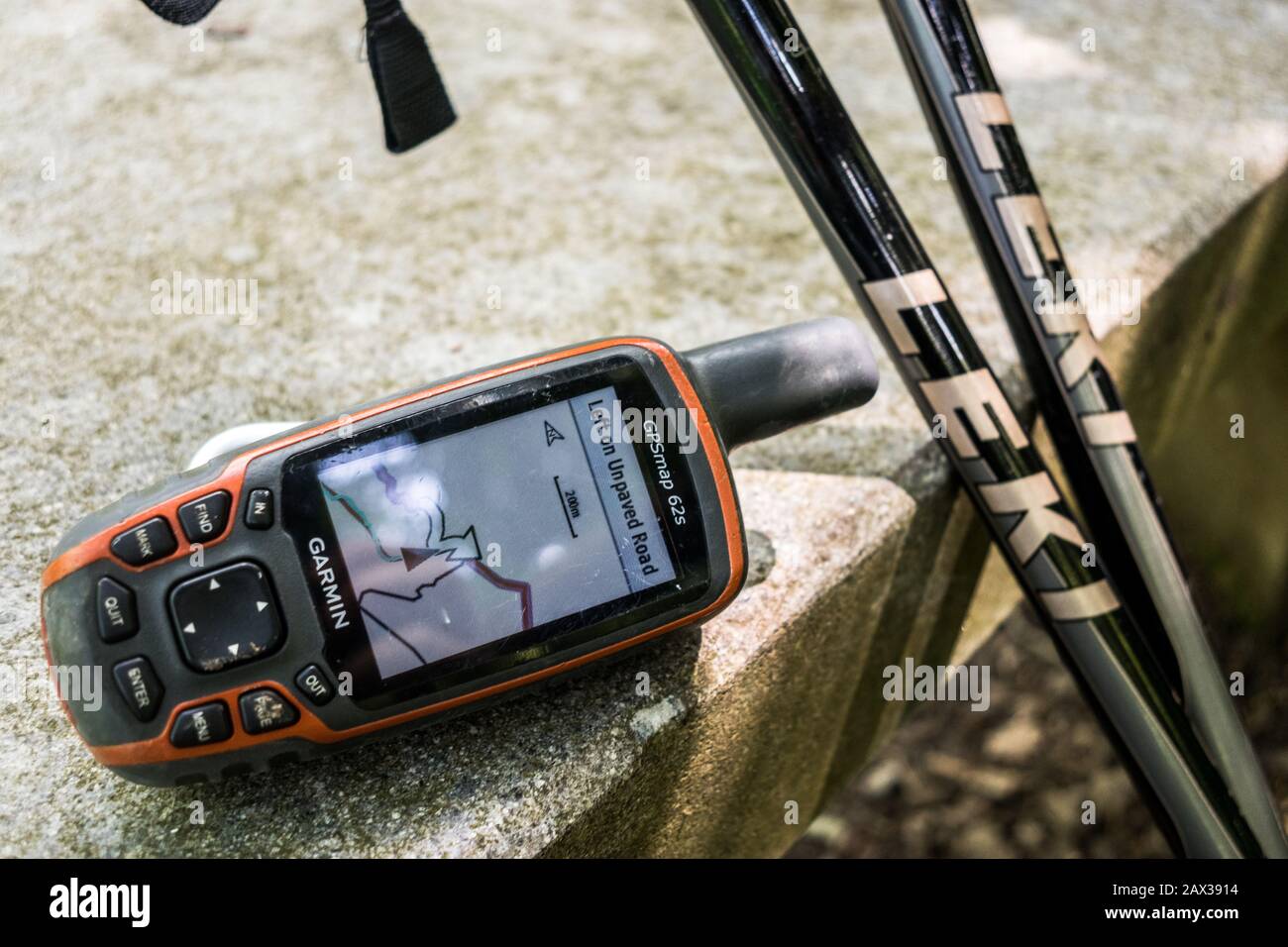 Garmin GPS displaying map giving directions to unpaved road with Leki hiking poles Stock Photo
