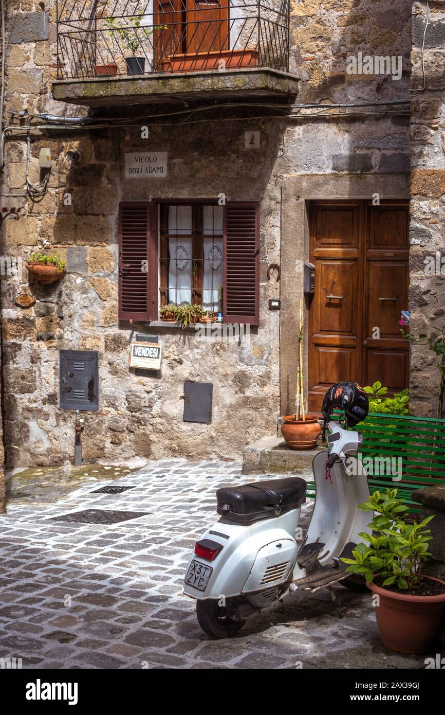 Scooter outside house for sale in old narrow cobbled street in the old