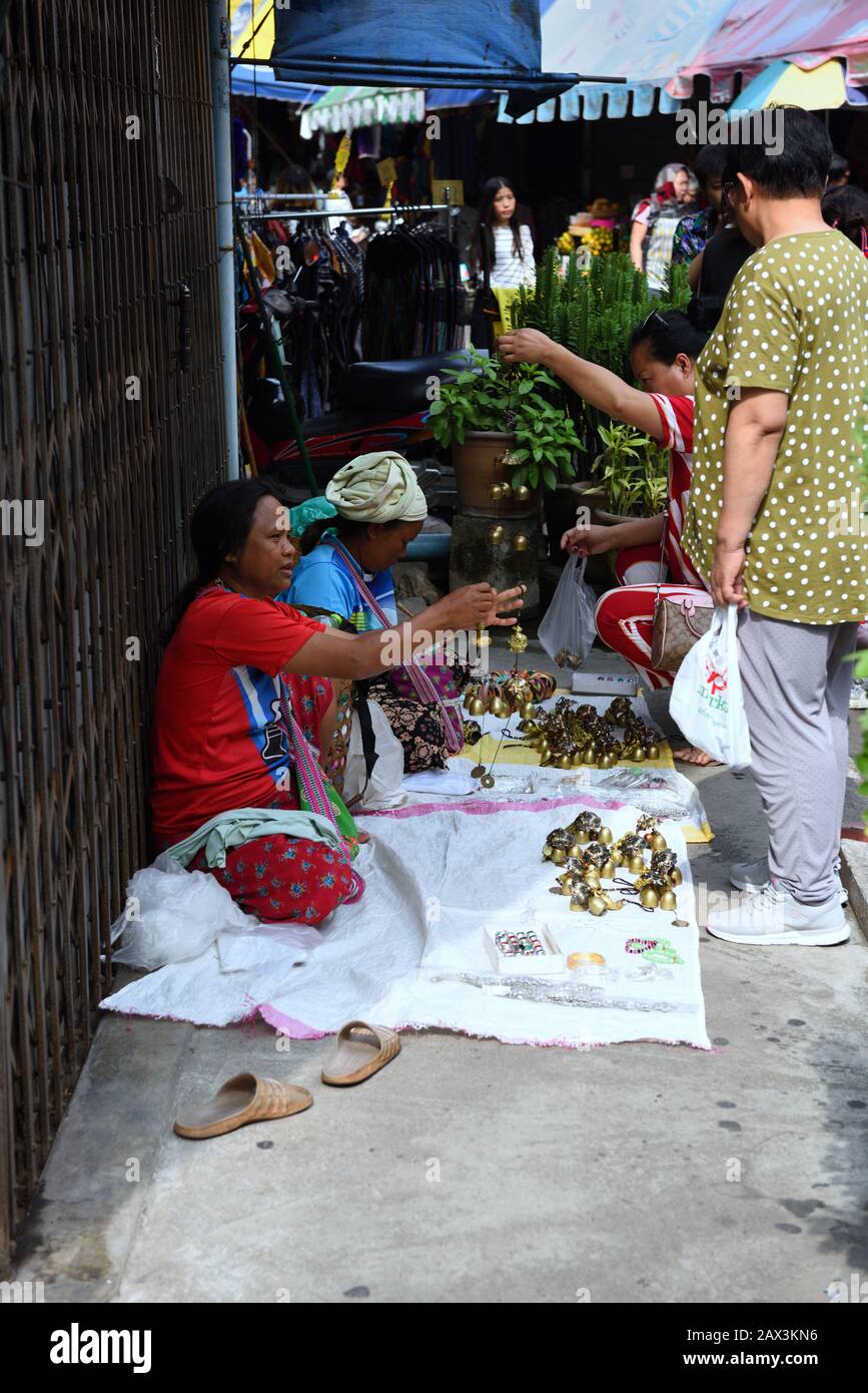 Women from a mountain village selling bells as good luck charms in a street market, Chiang Mai, Thailand Stock Photo