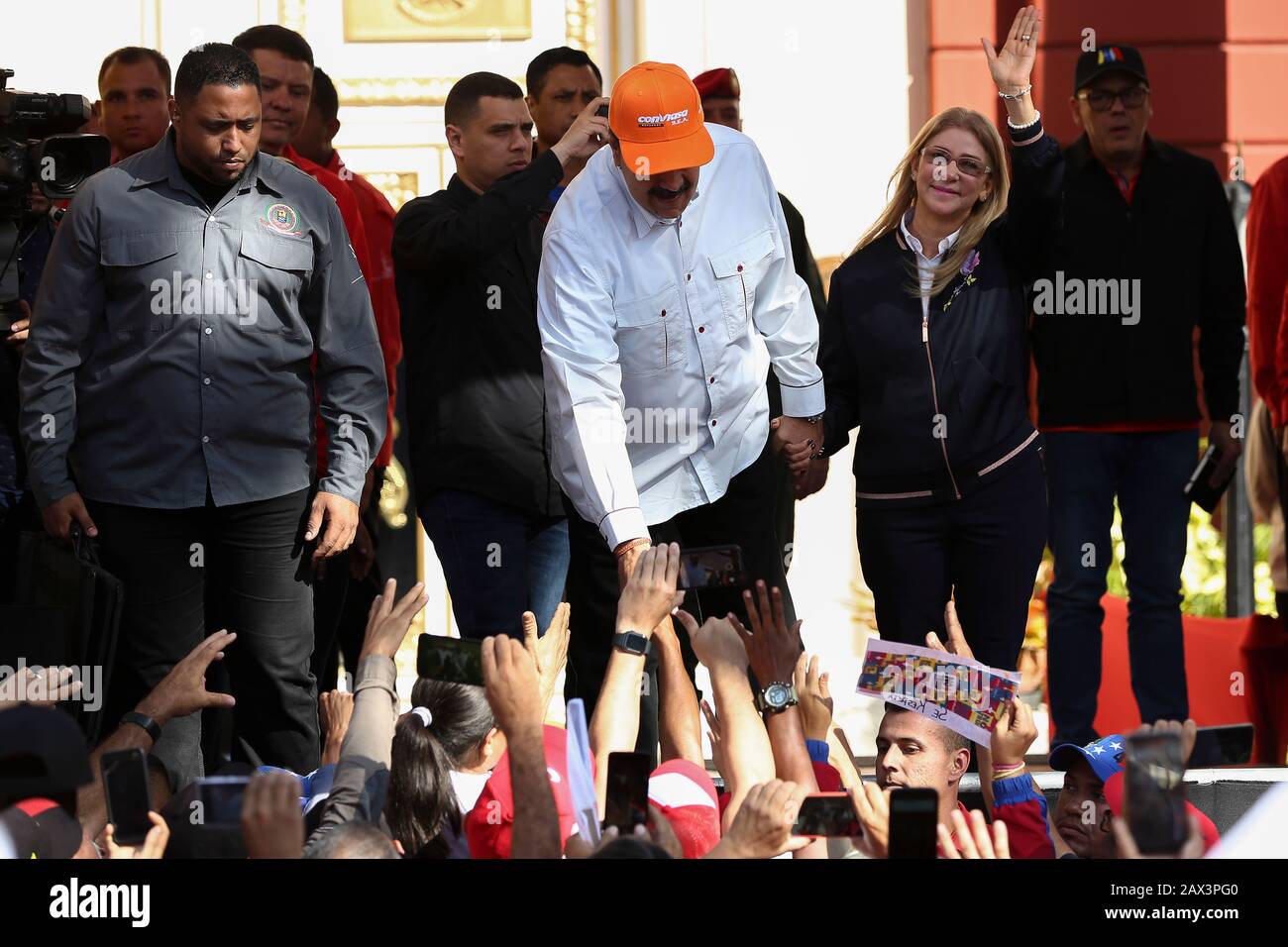10 February 2020, Venezuela, Caracas: Nicolas Maduro (M.), President of Venezuela, wears a cap of the Venezuelan airline Conviasa and waves with his wife Cilia Flores (r) to supporters in a protest against the announcement of new US sanctions against the Venezuelan airline. 'The state airline Conviasa supports the illegal regime of Maduro by flights of officials of his corrupt regime around the world,' the U.S. Treasury Department quoted Treasury Secretary Mnukhin in the announcement. Before supporters, the Venezuelan head of state countered: 'We will appeal to the International Court of Justi Stock Photo