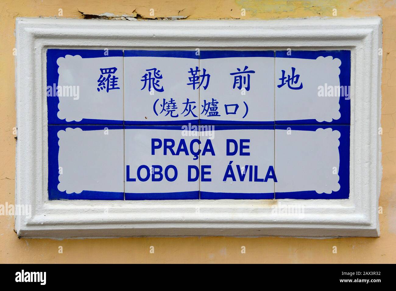A road sign in Macau in Chinese and Portugese for the Praca de Lobo de Avila on a wall Stock Photo
