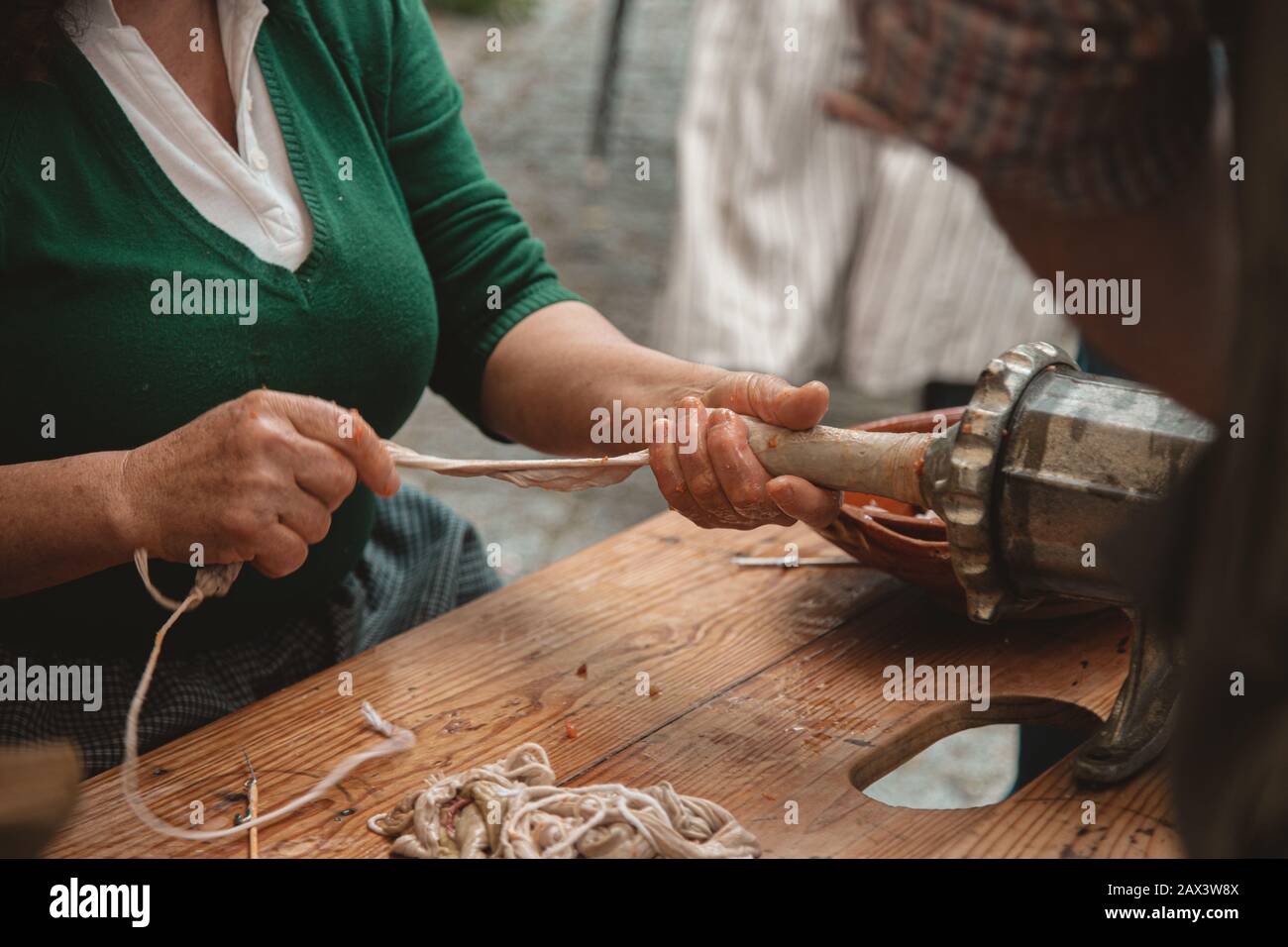 Picture of people preparing a kielbasa with an oldfashioned meat