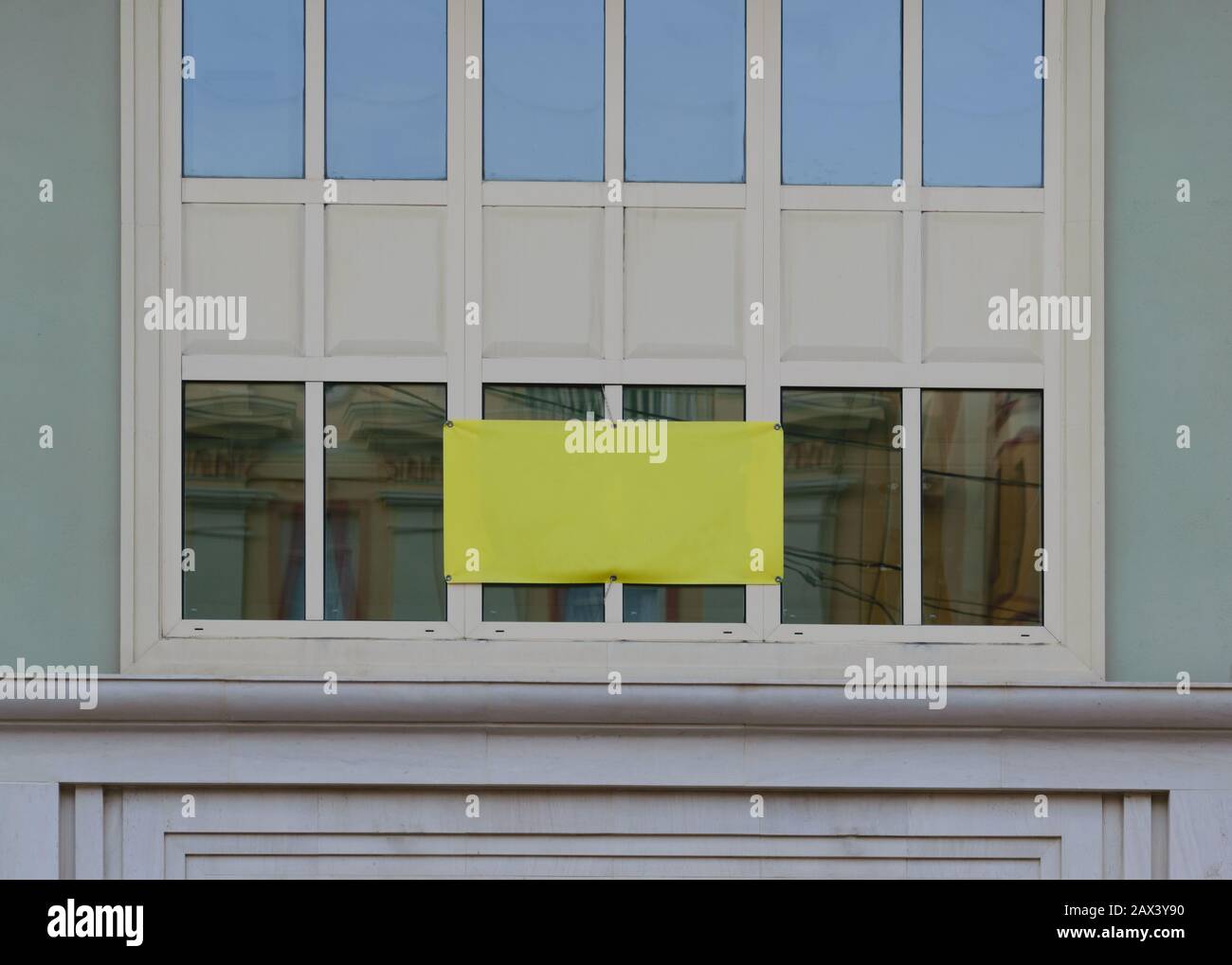 Wide shot of the yellow plastic sheet covering two window panels of a