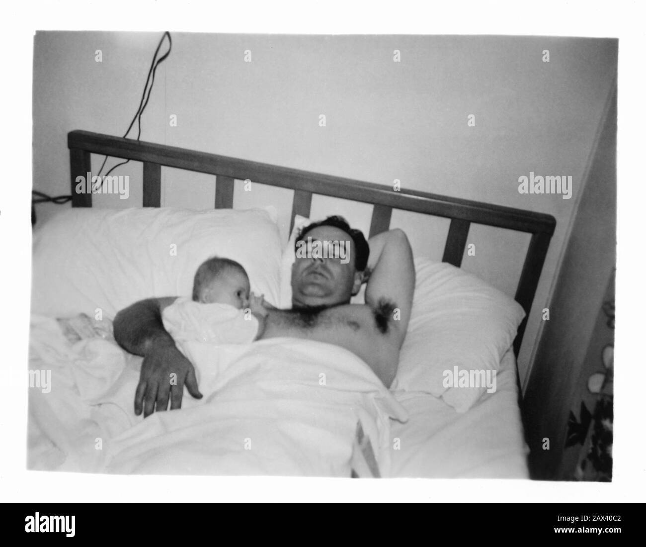 1944 , USA : A father with little child son   - FOTO STORICHE - HISTORY PHOTOS -  BAMBINA -  CHILD - BAMBINO - BAMBINI - BAMBINE - CHILDREN -  tenerezza - tenderly - CHILDREN - BAMBINA - BABY - NOVECENTO - 900's - '900 - BABY -  bebé  - CHILDHOOD - INFANZIA - padre - figlio - figlia - papa' - letto - bed - abbraccio - embrace - tenderly - bedroom - camera da letto - foto amatoriale non professionale - Istamatick   ----- Archivio GBB Stock Photo